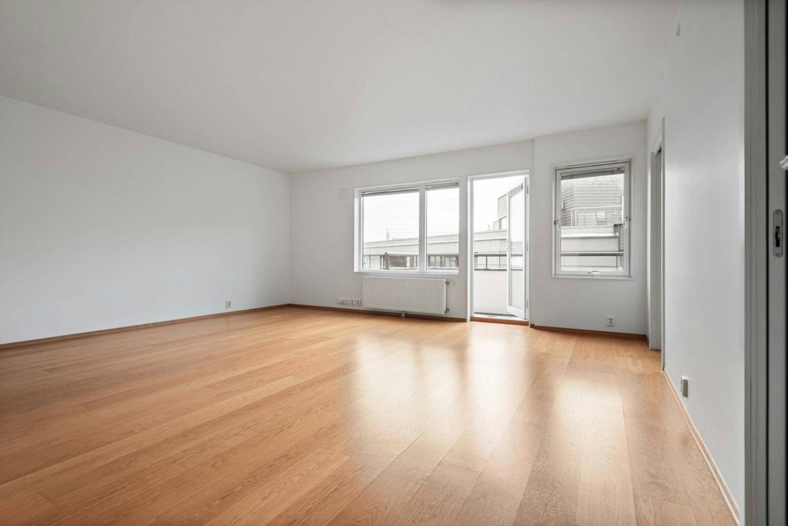An empty, freshly cleaned flat with wooden floors and white walls